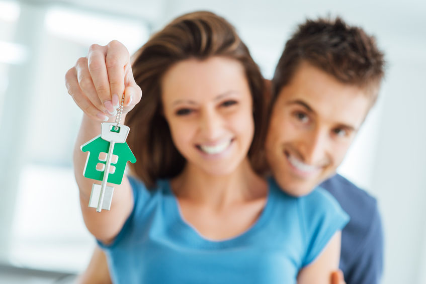 First Time Buyers - Young smiling couple holding their new house keys